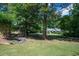 Lush green front yard leading to a well-maintained home with mature trees at 59 Woodlawn Dr, Marietta, GA 30067
