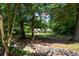 Beautifully landscaped front yard featuring a stone water feature and mature trees at 59 Woodlawn Dr, Marietta, GA 30067