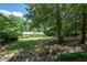 Spacious front yard of a charming home surrounded by mature trees and professional landscaping at 59 Woodlawn Dr, Marietta, GA 30067