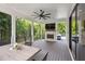 Covered back porch with a fireplace, outdoor TV, fan, and dining area overlooking wooded backyard at 159 E Wesley Ne Rd, Atlanta, GA 30305