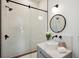 Modern bathroom featuring a sliding glass door shower and stylish round mirror at 159 E Wesley Ne Rd, Atlanta, GA 30305