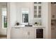 Elegant wet bar featuring white cabinetry, marble countertops, wine fridge, and glass display cabinet at 159 E Wesley Ne Rd, Atlanta, GA 30305