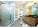 Bathroom featuring glass-enclosed shower, soaking tub, and updated vanity with elegant lighting at 5300 Peachtree Rd # 503, Atlanta, GA 30341