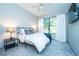 Bright bedroom featuring a ceiling fan, large window, and soft blue carpet at 5300 Peachtree Rd # 503, Atlanta, GA 30341