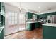 This renovated kitchen features beautiful green cabinets, stainless steel appliances, and terra cotta tile floors at 6 Westchester Sq, Decatur, GA 30030