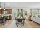 Open-concept dining area with modern light fixtures, hardwood floors, and access to the kitchen at 106 Asher Dr, Carrollton, GA 30116