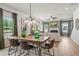 Open dining area flows into living room and features a large wooden table and modern light fixtures at 106 Asher Dr, Carrollton, GA 30116