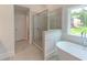 Well-lit bathroom featuring a glass-enclosed shower, a luxurious soaking tub, and tiled flooring at 3292 Mill Forest Sw Dr, Conyers, GA 30094