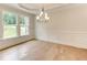 Bright dining room featuring hardwood floors, wainscoting, and a modern chandelier at 3292 Mill Forest Sw Dr, Conyers, GA 30094