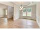 Open-concept dining area with hardwood floors, a stylish chandelier, and large windows at 3292 Mill Forest Sw Dr, Conyers, GA 30094