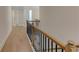 Hallway with light wood floors and black metal and wood bannister at 3292 Mill Forest Sw Dr, Conyers, GA 30094