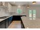 Granite counters and stainless appliances adorn this kitchen with white cabinets and contrasting black lower cabinets at 3292 Mill Forest Sw Dr, Conyers, GA 30094
