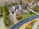 Aerial view of a beautiful brick home featuring lush landscaping and a circular driveway at 3821 Teesdale Ct, Atlanta, GA 30350
