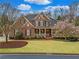 Elegant brick home with a welcoming front porch and beautifully landscaped front yard showcasing mature trees at 3821 Teesdale Ct, Atlanta, GA 30350