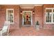 Grand entrance to a brick home with a brick porch, flanked by potted plants and classic lanterns at 3821 Teesdale Ct, Atlanta, GA 30350