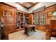 Wood-paneled office with custom bookshelves and natural light from large windows at 3821 Teesdale Ct, Atlanta, GA 30350