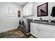 Well-lit laundry room with modern washer and dryer, and convenient sink area at 3821 Teesdale Ct, Atlanta, GA 30350