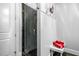 Modern shower with glass door, white wainscotting, and a small bench for convenience at 3821 Teesdale Ct, Atlanta, GA 30350