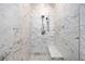 A stunning, tiled walk-in shower featuring marble accents and a built-in bench at 3821 Teesdale Ct, Atlanta, GA 30350