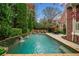 Lush backyard landscaping frames this swimming pool and stone patio, perfect for outdoor living at 3821 Teesdale Ct, Atlanta, GA 30350
