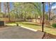 Spacious fenced backyard with a concrete patio area and mature trees for shade at 713 Shore Ln, Lithonia, GA 30058