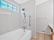 Tiled bathroom with bathtub and showerhead, as well as a blue stained glass window at 713 Shore Ln, Lithonia, GA 30058
