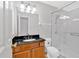 Well-lit bathroom featuring a glass enclosed shower, black granite countertop and wood cabinets at 713 Shore Ln, Lithonia, GA 30058