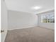 Bright, carpeted bedroom featuring neutral walls and a large window with blinds at 713 Shore Ln, Lithonia, GA 30058
