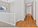Upstairs hallway with hardwood floors, white walls, and a railing at 713 Shore Ln, Lithonia, GA 30058
