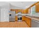 Well-lit kitchen featuring stainless steel appliances, wood cabinets, and granite countertops at 713 Shore Ln, Lithonia, GA 30058