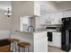 Bright kitchen with white cabinets, marble countertops, and bar stool seating at 1 Biscayne Nw Dr # 211, Atlanta, GA 30309