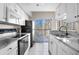 Bright kitchen features white cabinets, stainless appliances, granite countertops, and sliding doors to balcony at 1 Biscayne Nw Dr # 211, Atlanta, GA 30309