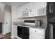 Well-lit kitchen features white cabinets, marble countertops, and modern appliances at 1 Biscayne Nw Dr # 211, Atlanta, GA 30309