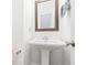 Elegant powder room featuring a pedestal sink, mirror, and neutral walls at 3260 Bennett Creek Ln, Suwanee, GA 30024