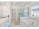 Bright bathroom features a glass shower with a soaking tub and marble tile at 3260 Bennett Creek Ln, Suwanee, GA 30024