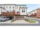 View of townhomes, each with a one-car garage and a small deck above it at 3260 Bennett Creek Ln, Suwanee, GA 30024