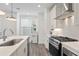 Bright kitchen featuring stainless steel appliances, white cabinets, quartz counters and stylish backsplash at 3260 Bennett Creek Ln, Suwanee, GA 30024