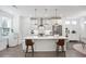 Bright kitchen with stainless steel appliances, white cabinetry, an island with bar seating, and modern lighting at 3260 Bennett Creek Ln, Suwanee, GA 30024