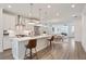 Open-concept kitchen featuring stainless steel appliances, white cabinets, an island with bar seating, and hardwood floors at 3260 Bennett Creek Ln, Suwanee, GA 30024