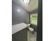 A half-bath features a toilet, window and a storage cabinet at 5160 Avery St, Covington, GA 30014