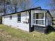 Side view of home highlighting updated siding, porch, and convenient utility connections, ensuring modern living at 5160 Avery St, Covington, GA 30014