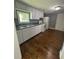 Efficient kitchen featuring modern appliances, white cabinets, and hardwood floors at 5160 Avery St, Covington, GA 30014
