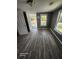 Bright living room with gray walls, modern floors, and a clear view to the outdoor area through multiple windows at 5160 Avery St, Covington, GA 30014