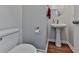 Small powder room with pedestal sink, toilet, and hardwood-style flooring at 121 Riverwatch Ct, Canton, GA 30114