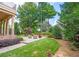 Inviting backyard with a stone patio, outdoor seating, a manicured lawn, and mature trees at 3299 Carmichael Pl, Duluth, GA 30097