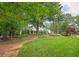 Lush backyard features a sprawling lawn, mature trees, and thoughtfully designed landscaping at 3299 Carmichael Pl, Duluth, GA 30097