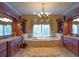 Luxurious primary bathroom with dual vanities, soaking tub, chandelier, and marble floors at 3299 Carmichael Pl, Duluth, GA 30097