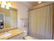 Well-lit bathroom with a granite countertop sink, a linen cabinet, a toilet, and a shower with a striped curtain at 3299 Carmichael Pl, Duluth, GA 30097