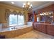 Beautiful bathroom with soaking tub, chandelier, and custom cabinets at 3299 Carmichael Pl, Duluth, GA 30097