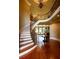 Magnificent foyer featuring a curved staircase, hardwood floors, elegant millwork, and bright natural light at 3299 Carmichael Pl, Duluth, GA 30097